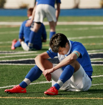a dejected PHS #7 sits on the field after the loss to South Plainfield.